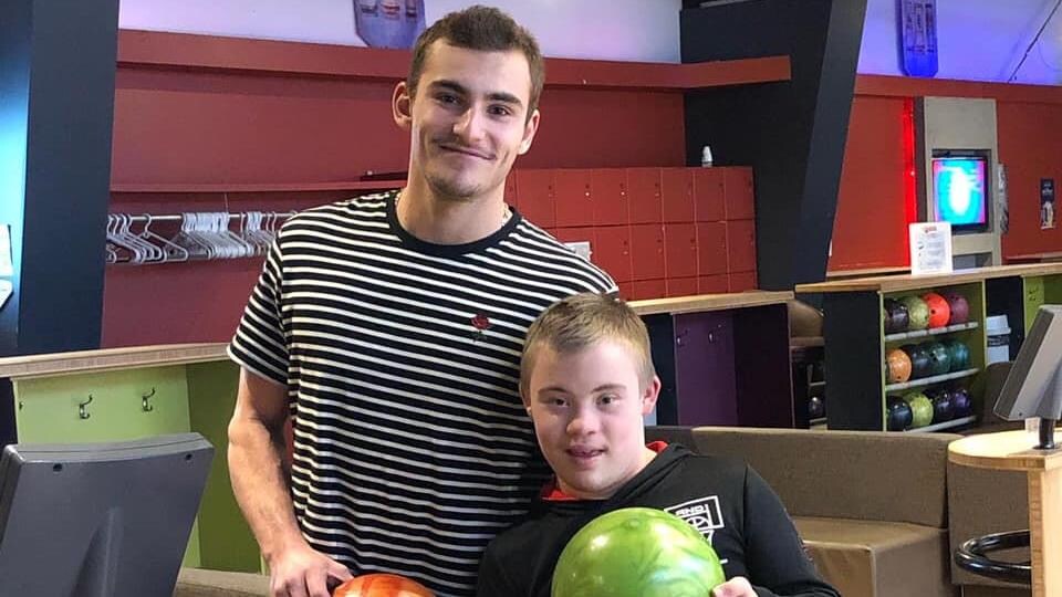 Mikael Martel pose avec Ely, un jeune homme qui vit avec la trisomie 21.
