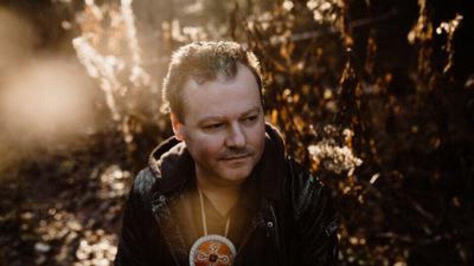 Mike Paul in a beam of light in the woods.