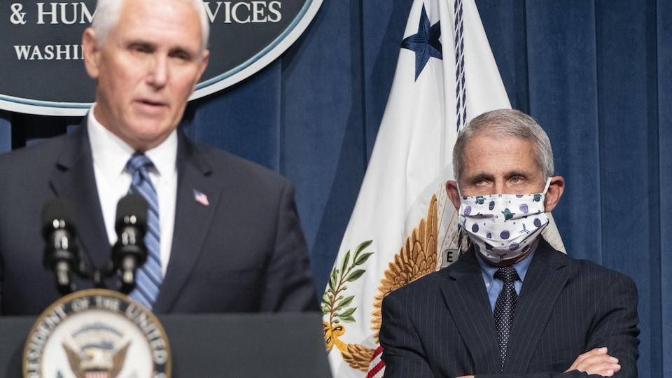 Le directeur de l'Institut national des allergies et des maladies infectieuses, Anthony Fauci, portant un masque, regarde le vice-président Mike Pence.
