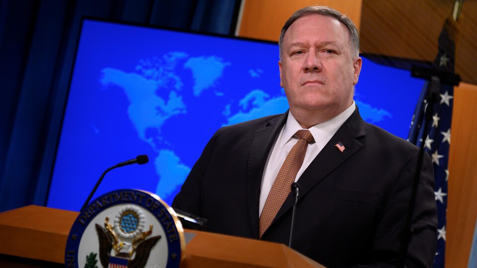 Mike Pompeo est debout derrière un lutrin et répond aux questions d'un journaliste.
