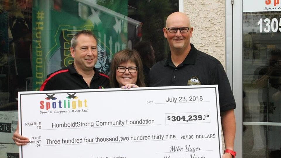L'imprimeur Mike Yager et sa femme Shannon tiennent un énorme chèque de 304 239 $ au côté du vice-président des Broncos, Randy MacLean