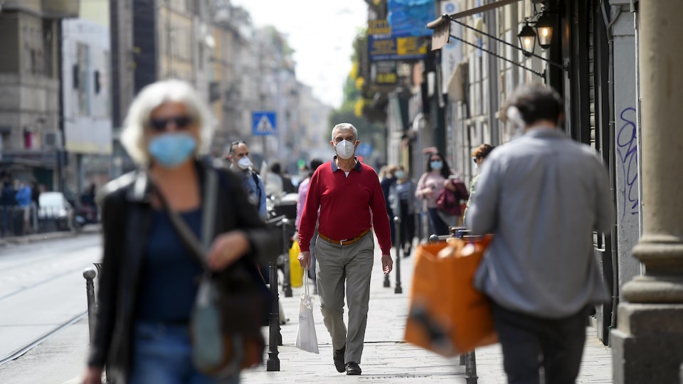 Plusieurs personnes marchent avec un masque.