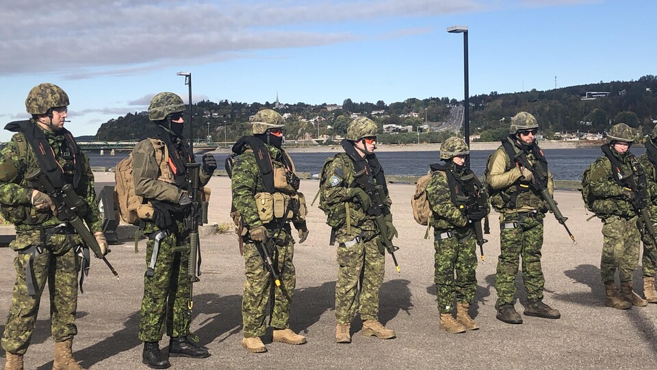 Des militaires devant la rivière Saguenay.