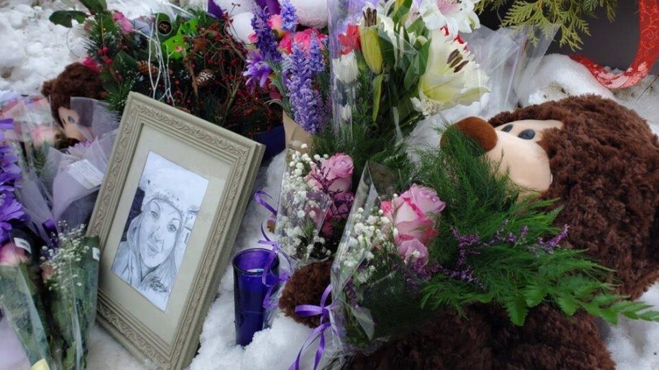 Un mémorial pour Mindy Godin avec des fleurs, des bougies et un ourson. 