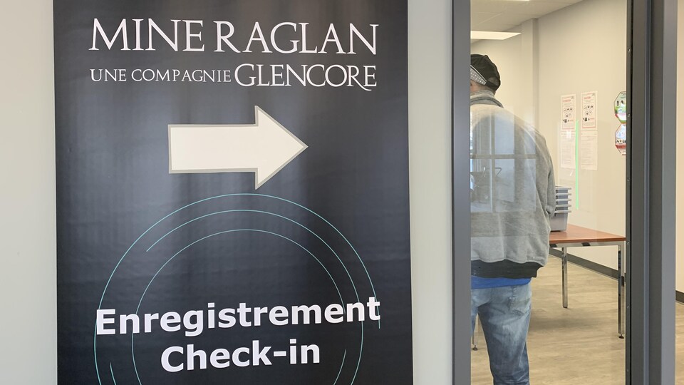 Une affiche indique «Mine Raglan une compagnie Glencore enregistrement check in».