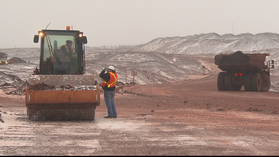Tracteur et travailleurs sur une mine