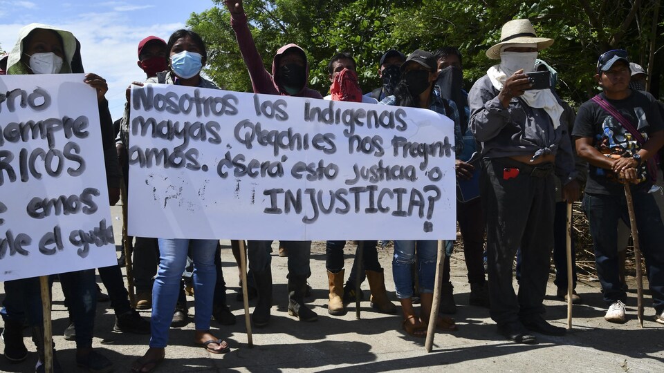 Des manifestants portent des pancartes.