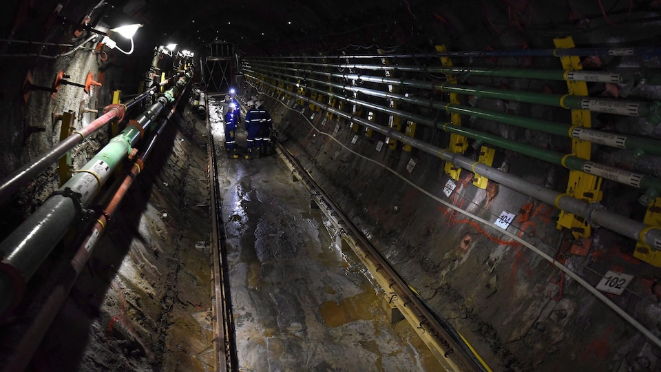 Un groupe de personnes se trouvent dans un tunnel d'une mine d'uranium.