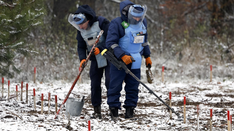 Des démineurs dans la neige.