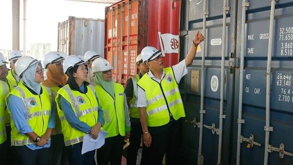 Le ministre malaisien de l'Environnement, Yeo Bee Yin (devant, 2e à gauche), et des fonctionnaires inspectent un conteneur rempli de déchets de plastique le 20 janvier 2020 avant de le renvoyer dans les pays d'origine à Butterworth.