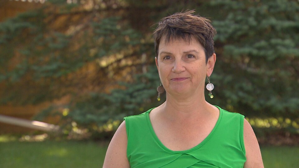 Mireille Péloquin devant une maison.