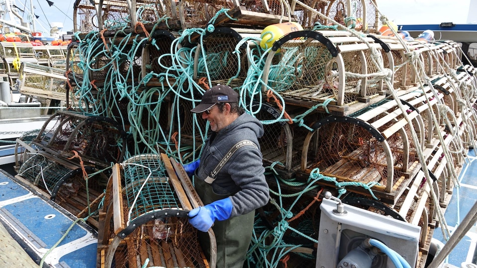 Un pêcheur qui empile les casiers dans sa remorque.