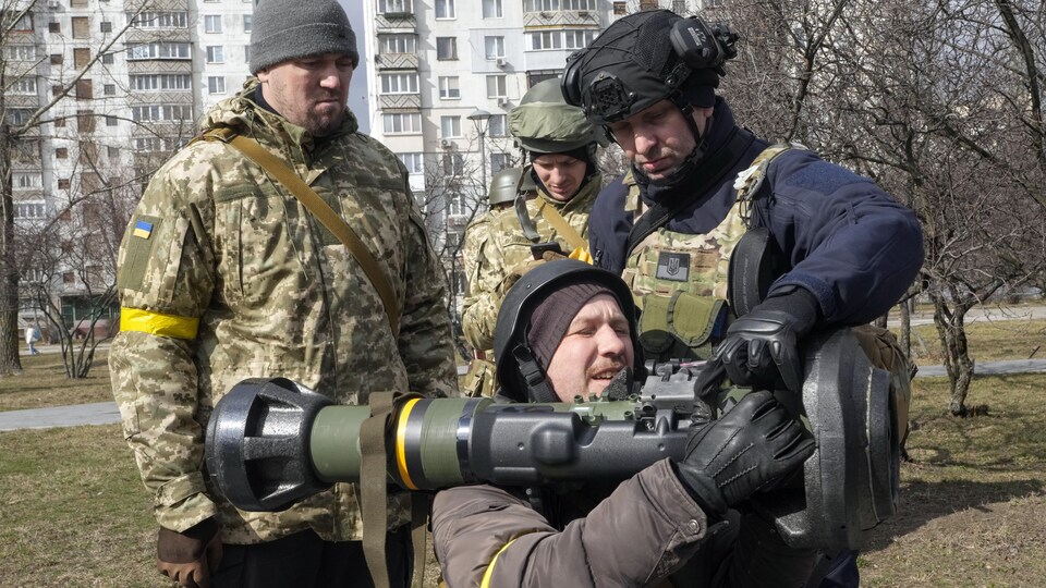 Des soldats apprennent à un volontaire ukrainien comment utiliser un lance-missile NLAW.