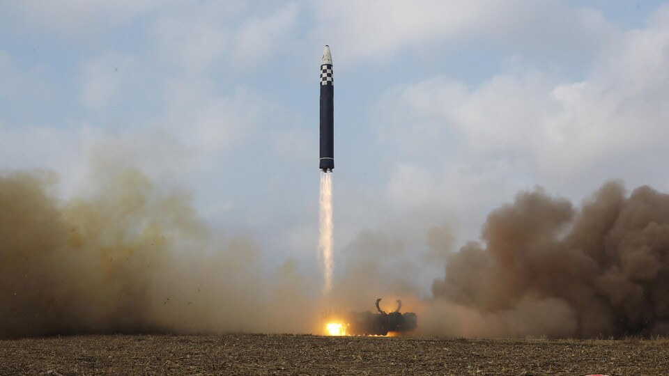 Tout juste lancé, un missile balistique est encore à quelques mètres du sol dans un nuage de fumée.