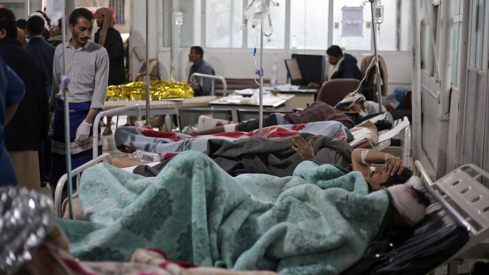 Des patients sont couchés sur des civières dans un hôpital.