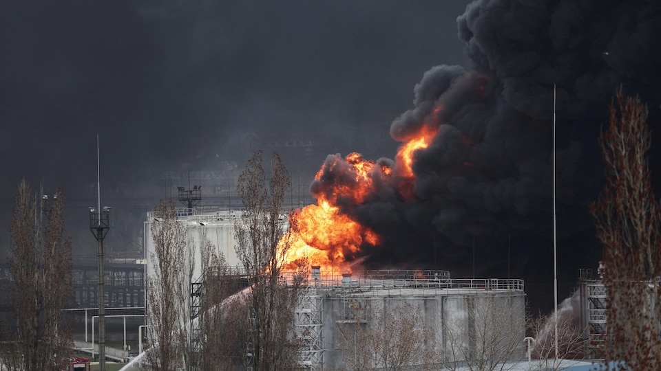Flames and a thick column of black smoke rose from a refinery. 