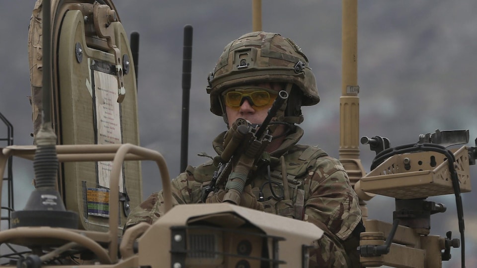 Un soldat en observation du haut d'un tank.