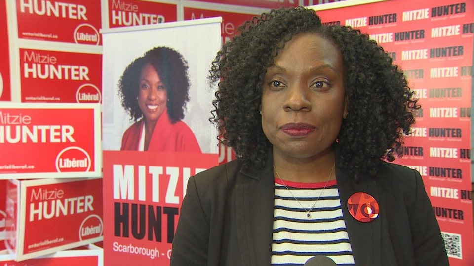  Mitzie Hunter devant des affiches de sa campagne électorale.