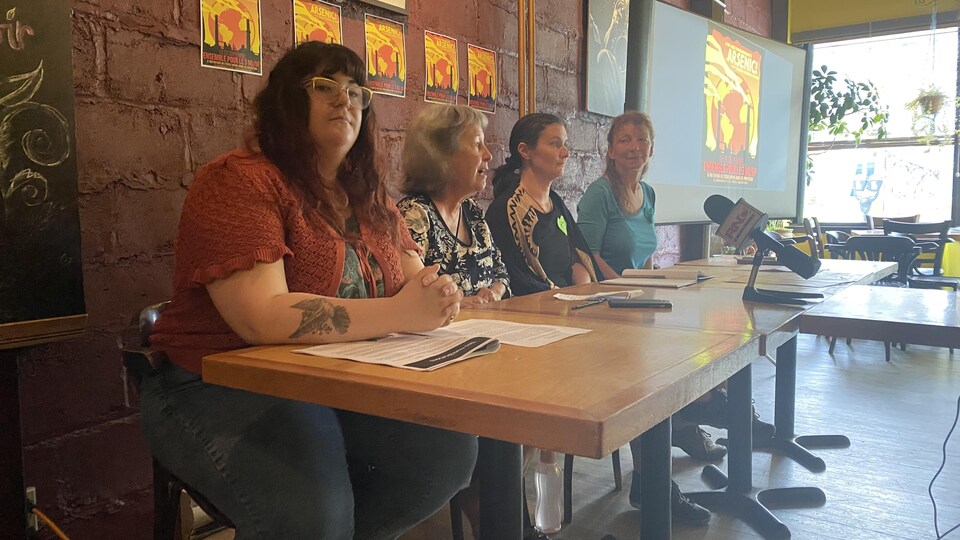 Quatre femmes assises derrière une table, en conférence de presse.