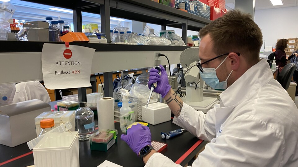 Un homme portant un masque travaillant dans un laboratoire