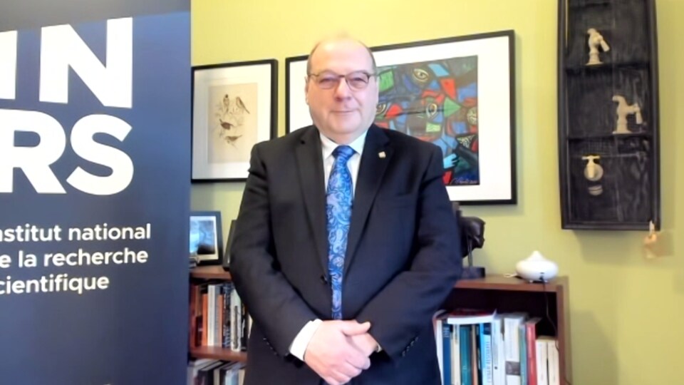 Un homme portant veston cravate dans son bureau de l'Institut national de la recherche scientifique.