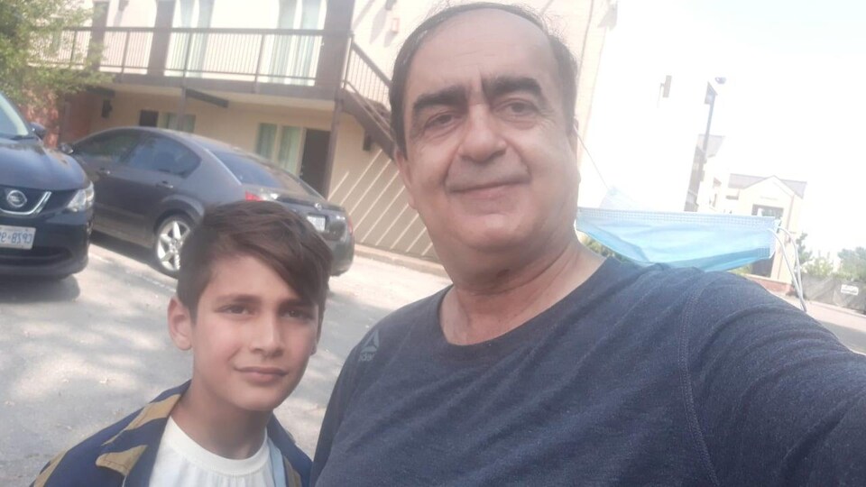 À gauche, le jeune Hadis et à droite, son grand-père Mohad, dans un stationnement à Toronto.