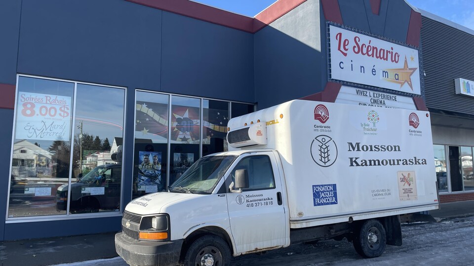 Un camion de Moisson Kamouraska stationné devant un cinéma.