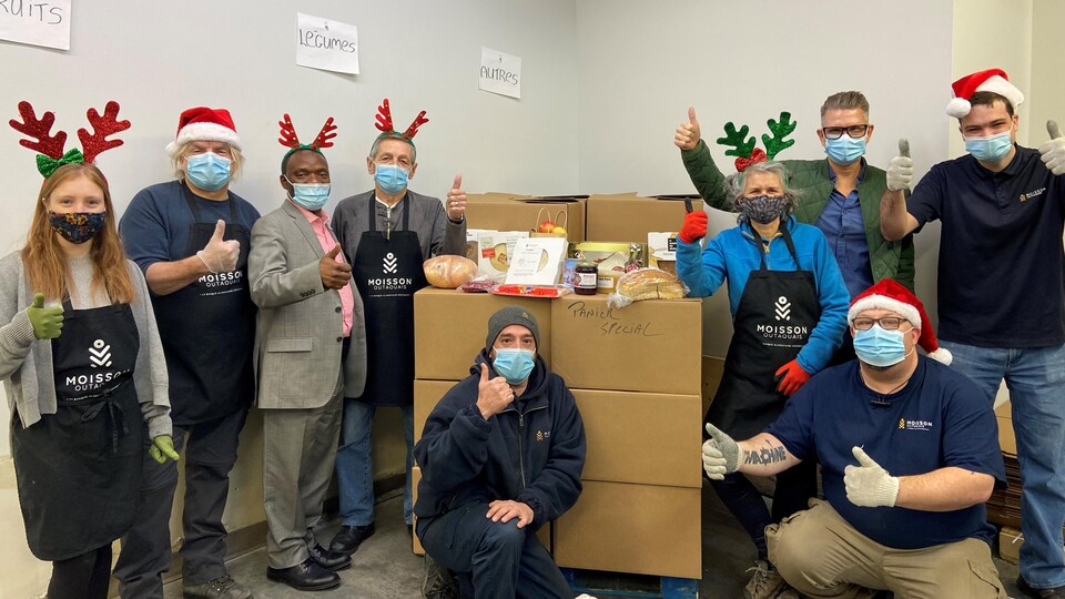 Des bénévoles de Moisson Outaouais posent devant les paniers de Noël.