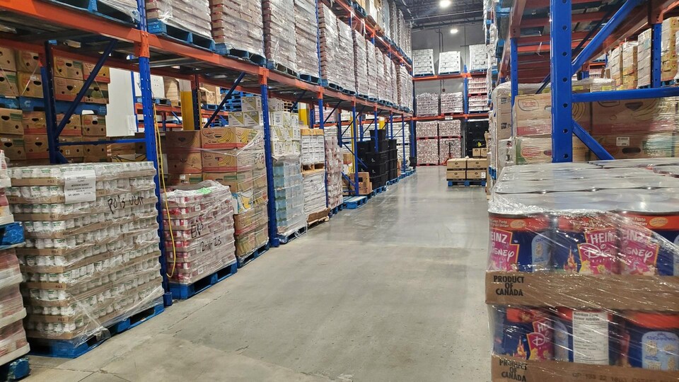 Un entrepôt avec des denrées alimentaires sur de grandes étagères.