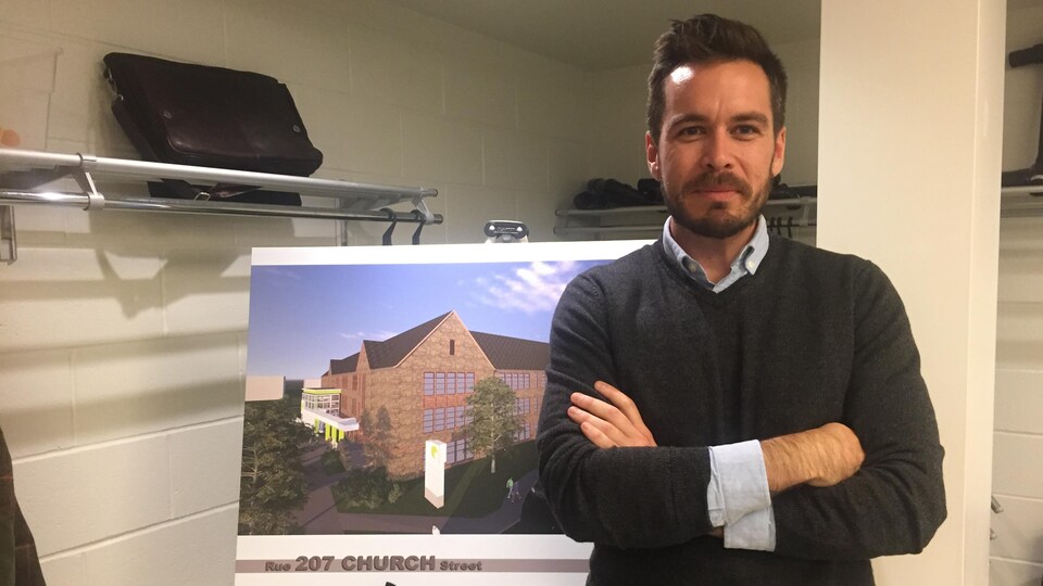 L'urbaniste principal de la Ville de Moncton, Sébastien Arcand, pose devant une maquette de l'ancienne école secondaire Moncton High.