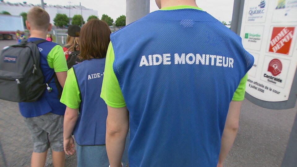 Des moniteurs de dos font la file pour entrer dans un parc.