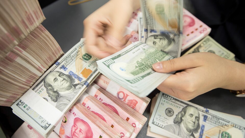 Des billets de dollars américains et de yuans chinois.