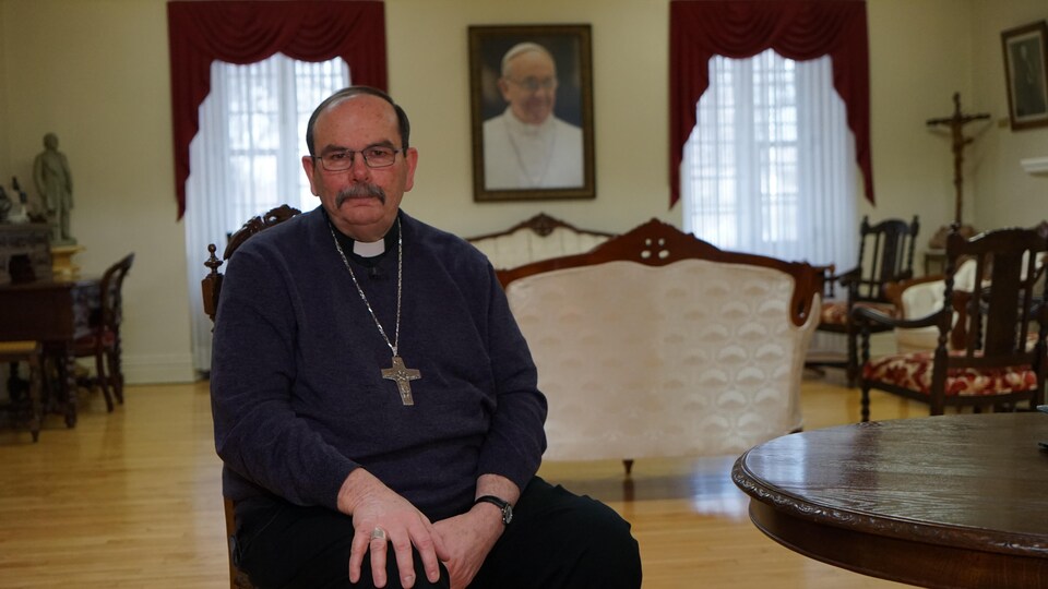 Monseigeur Albert LeGatt pose devant un portrait du pape François à Winnipeg, le 5 avril 2022.