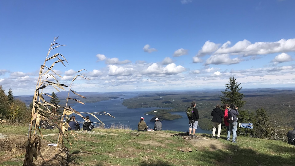 La vue du haut du Mont Owl's Head. Des touristes photographient le lac Memprhémagog ou pique-niqueny.