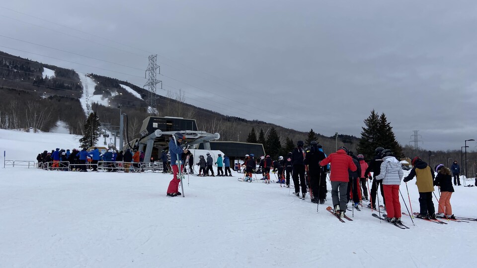 Des personnes font la file devant le télésiège du Mont-Sainte-Anne.