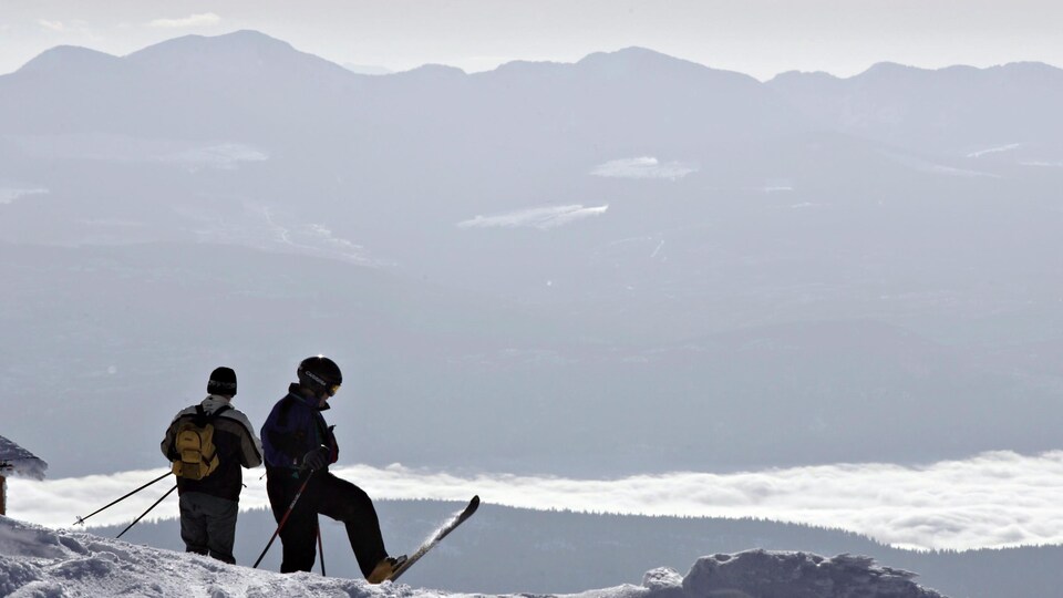 Des skieurs au sommet d'une montagne.