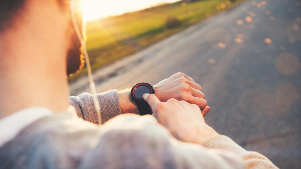 Un coureur vérifie sa montre.
