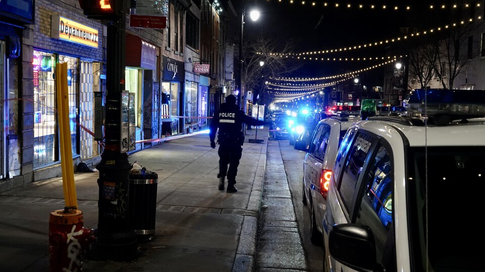 Un agent du Service de police de la Ville de Montréal établit un périmètre de sécurité.