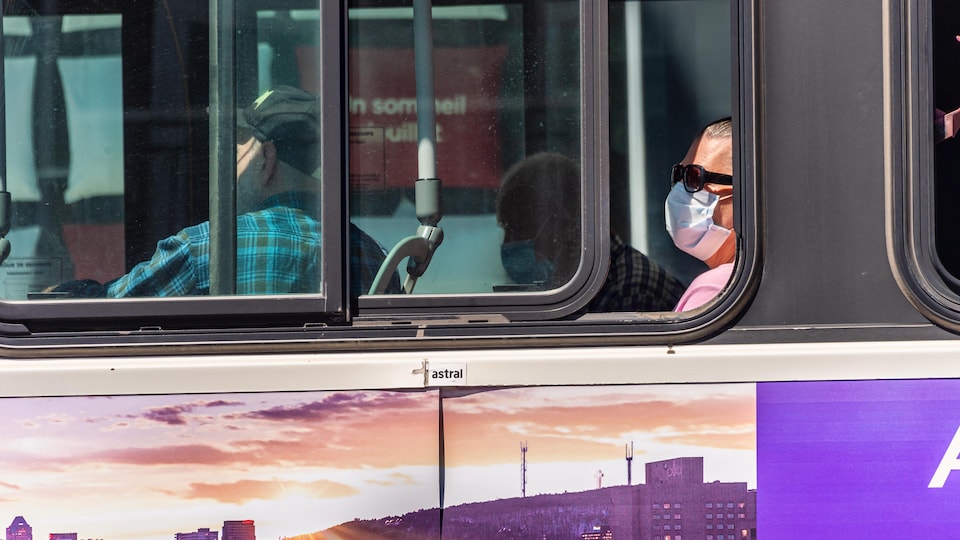 Une femme portant un masque dans l'autobus.