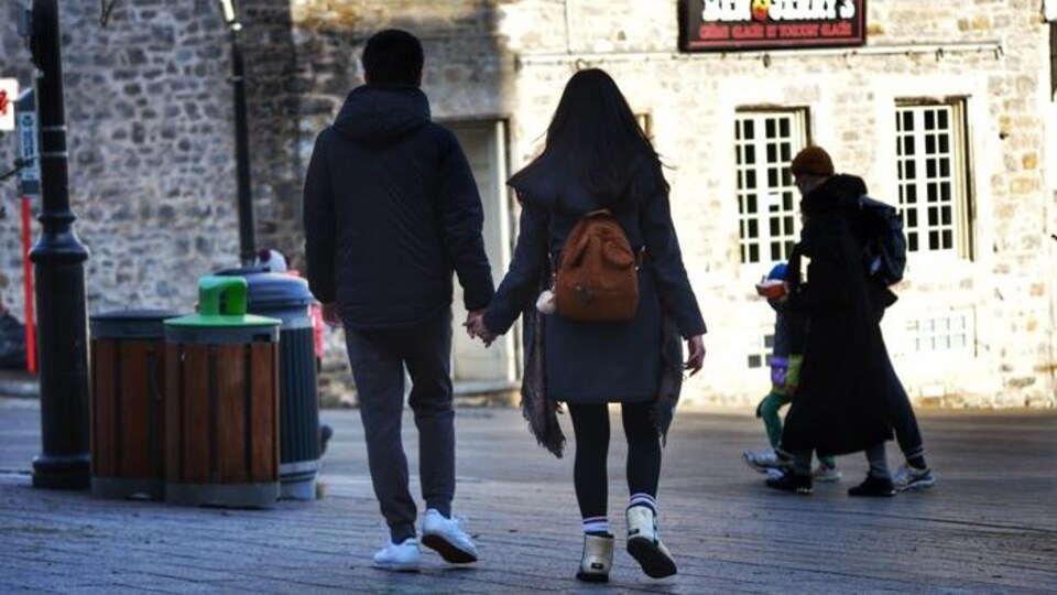 Des adultes et un enfant marchent dans une rue de Montréal.