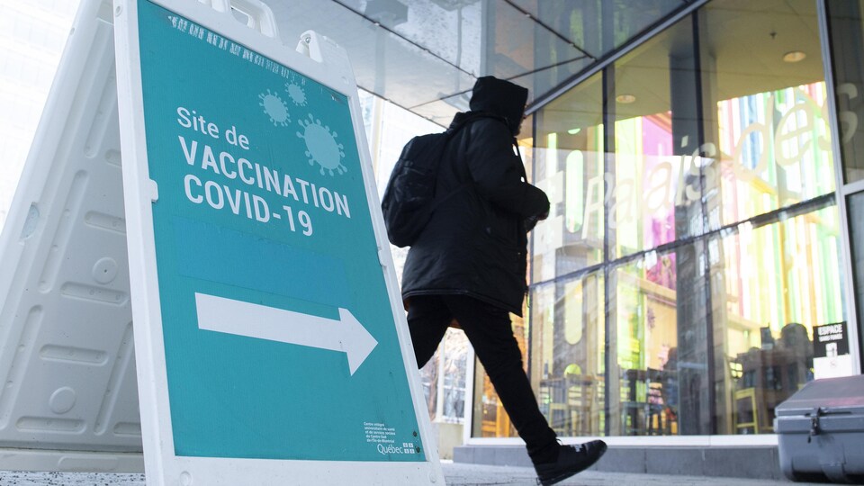 Un homme passe devant un centre de vaccination contre la COVID-19 à Montréal.