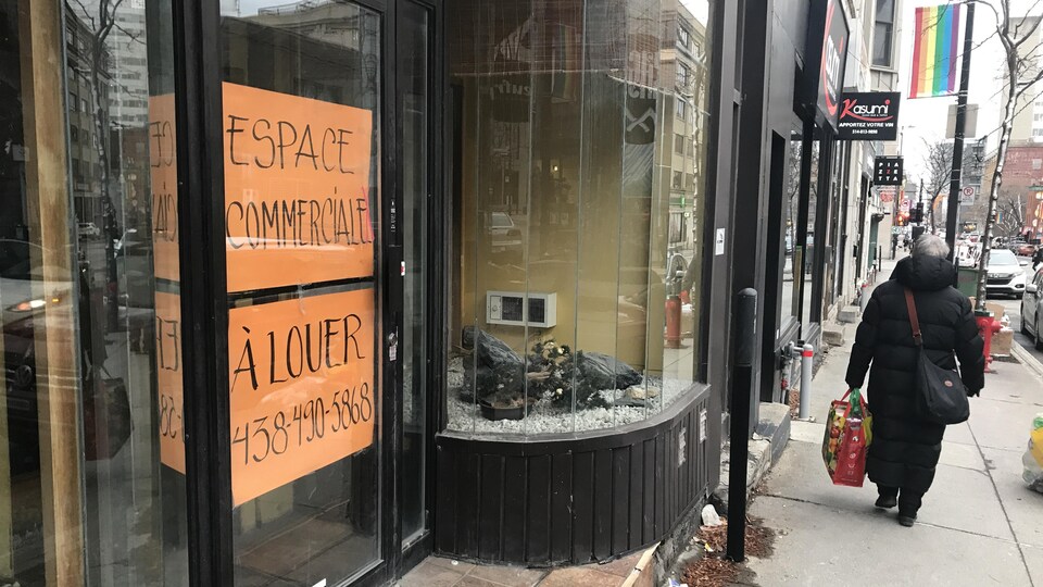 Une affiche à louer se trouve dans la fenêtre d'un local du centre-ville de Montréal.