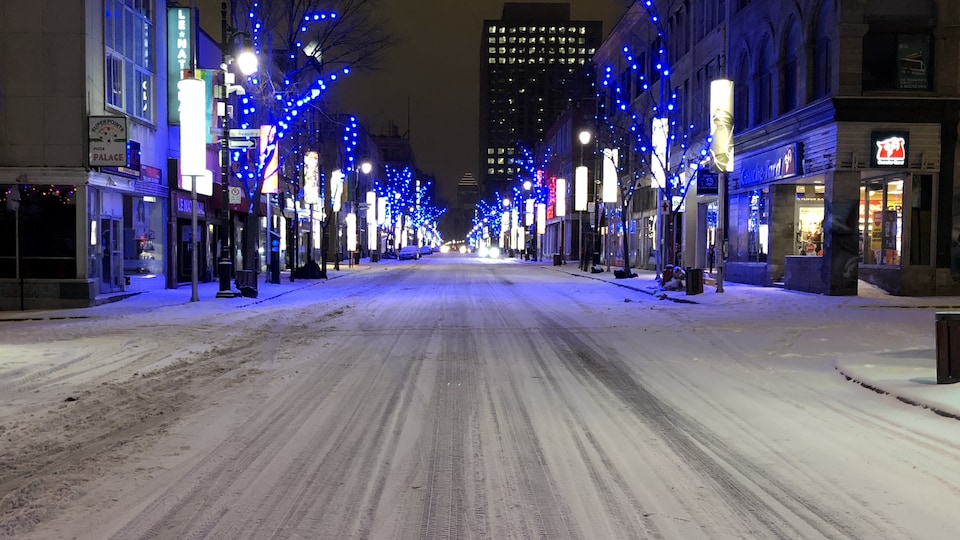 La rue Sainte-Catherine est déserte, tôt le matin, et est bordée de lumière bleue.
