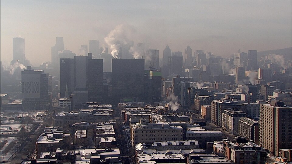 Des bâtiments et des buildings sous un ciel brumeux et brunâtre.