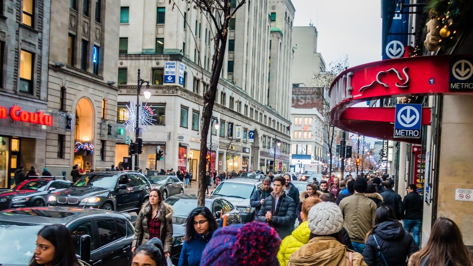 Des piétons marchent sur la rue Sainte-Catherine au centre-ville de Montréal.