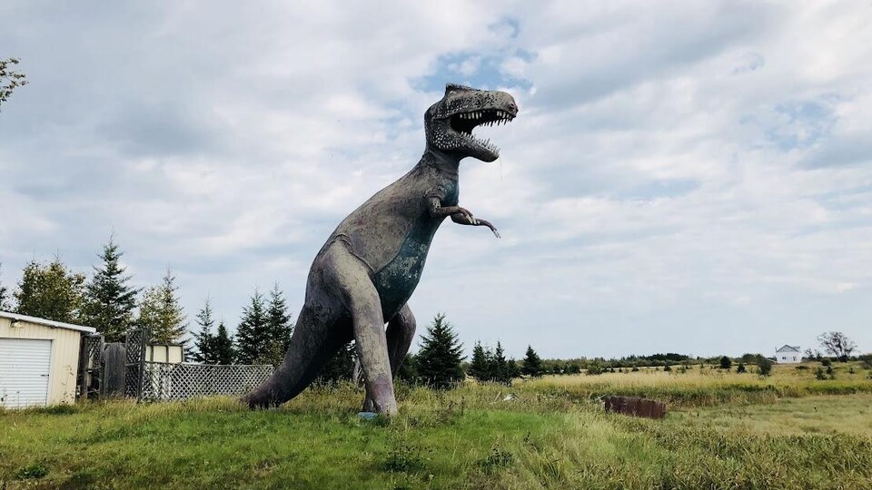 La statue montre le tyrannosaure la gueule ouverte et les crocs sortis. 
