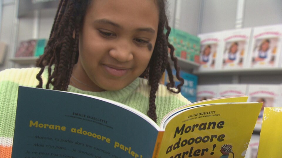 Morane qui tient le livre d'Émilie Ouelette Morane adore parler!