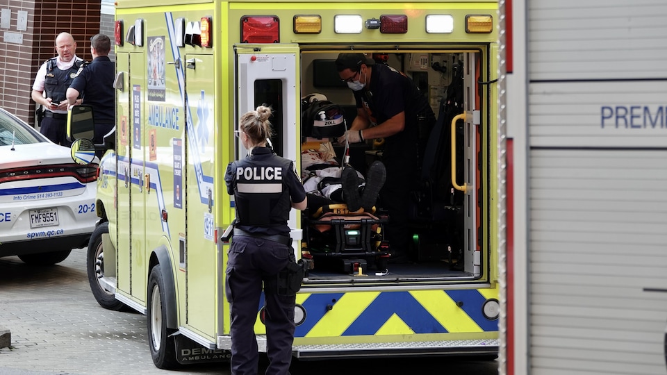 Un ambulancier prodigue les premiers soins à une des victimes de l'attaque à l'arme blanche.
                     