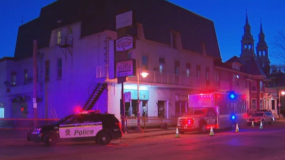 Un véhicule de la Sûreté du Québec et un véhicule du Bureau des enquêtes indépendantes dans la rue le soir.