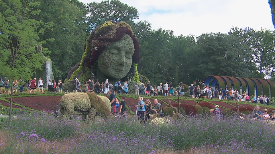 Des visiteurs contemplent les sculptures végétales.